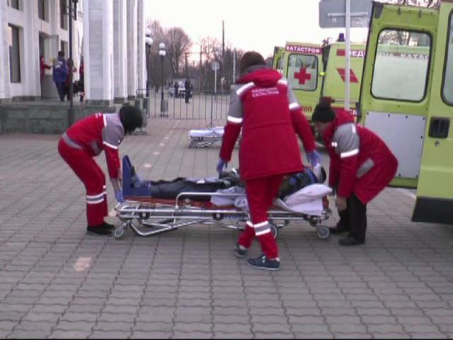 Вынос пострадавших из здания железнодорожного вокзала в карету скорой помощи